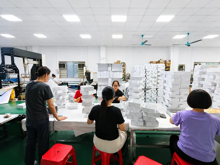 Workers hand assembling custom rigid packaging boxes in the factory